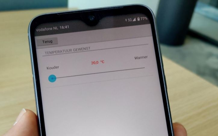 Smartphone met app voor bijstelling van de temperatuur. 