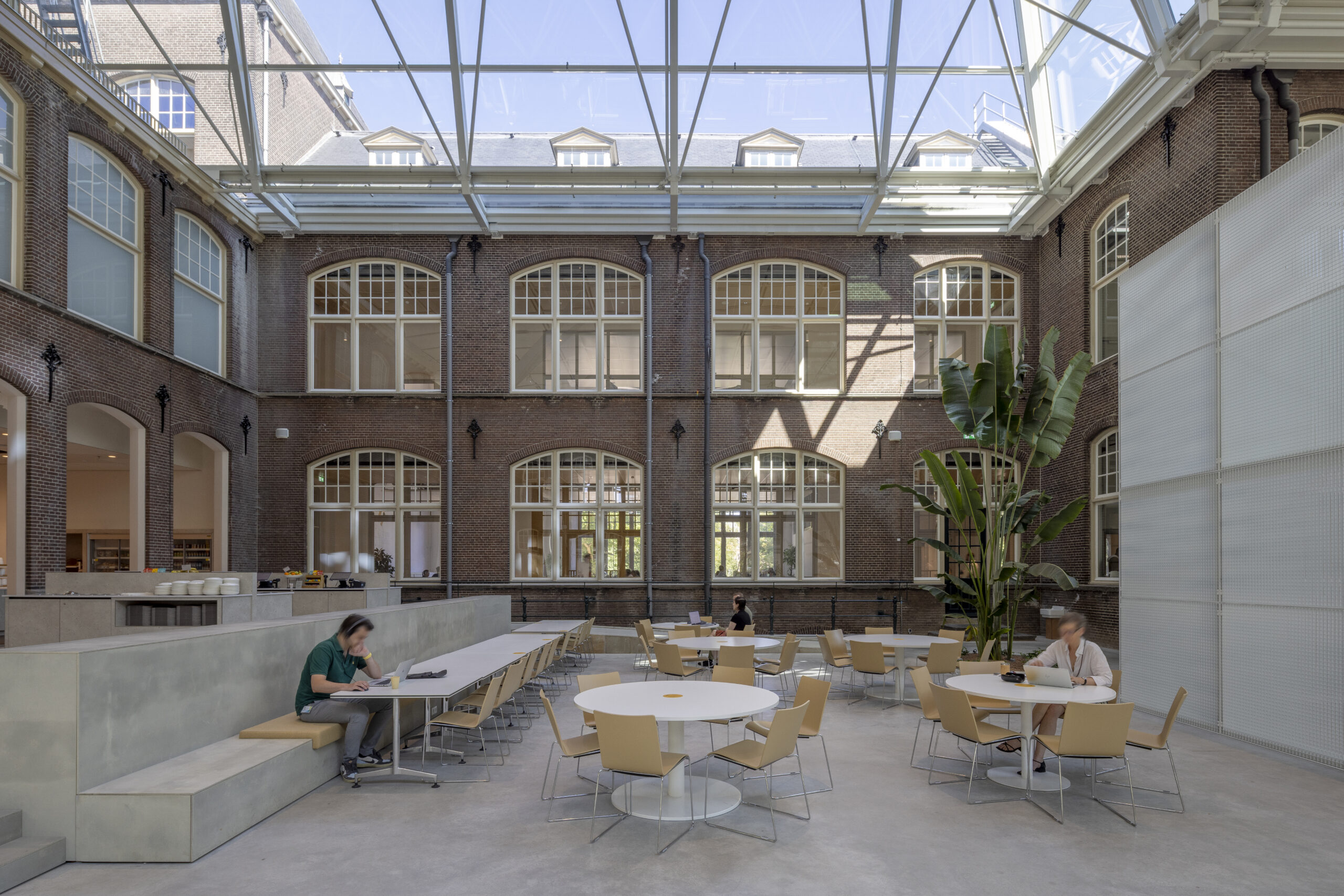 Werkplekken in een van de atria. Beeld door Lucas van der Wee