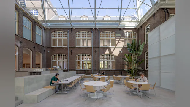 Werkplekken in een van de atria. Beeld door Lucas van der Wee