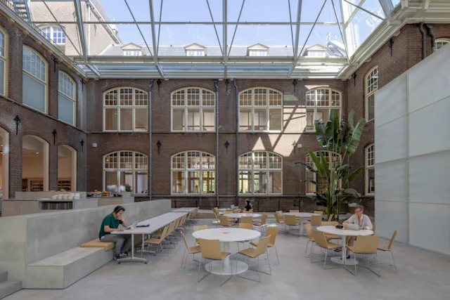 Werkplekken in een van de atria. Beeld door Lucas van der Wee