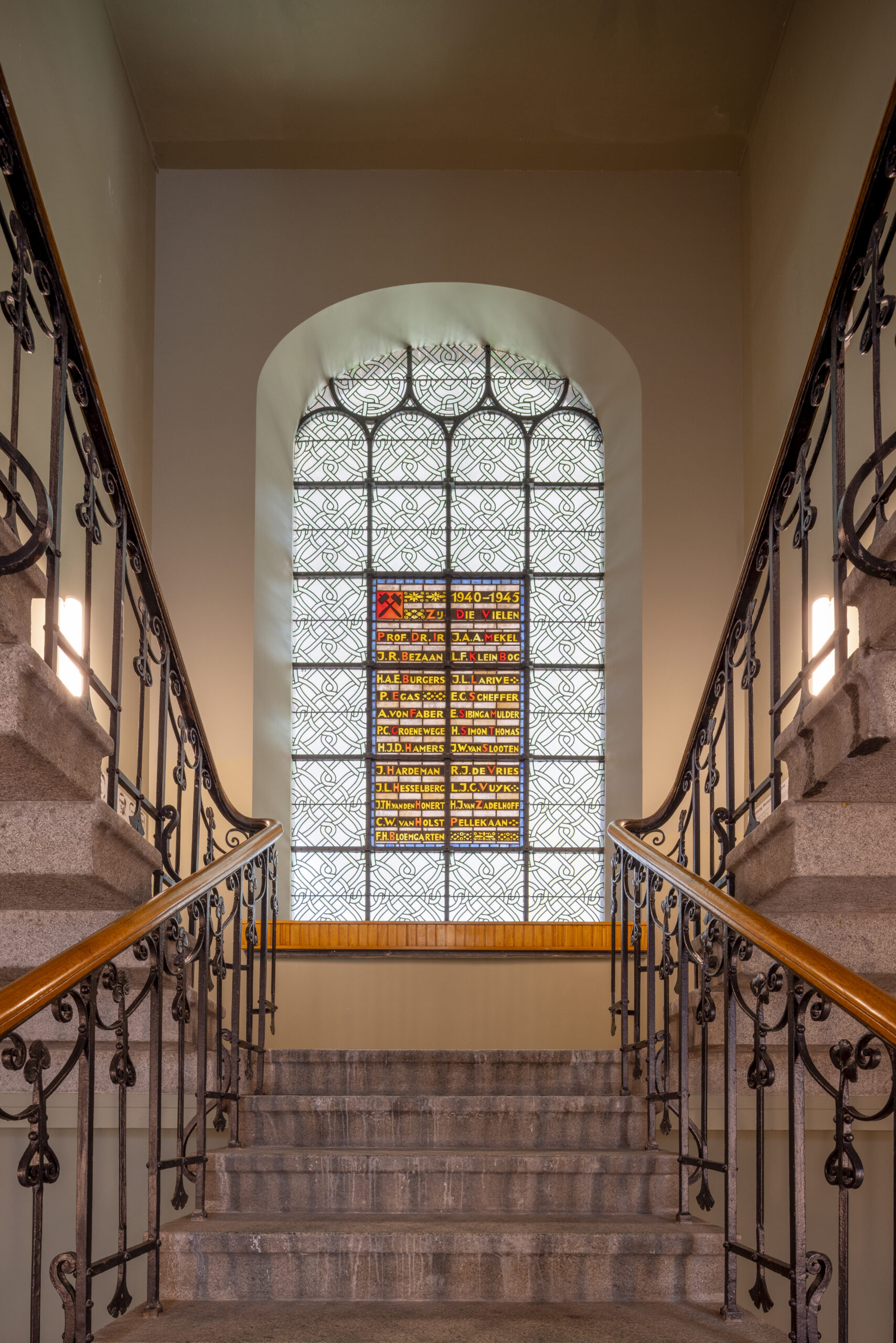 De gerenoveerde hoofdtrap, waar beide ingangen naartoe leiden, inclusief een herdenkenis van de Tweede Wereldoorlog in glas-in-lood. Beeld Lucas van der Wee