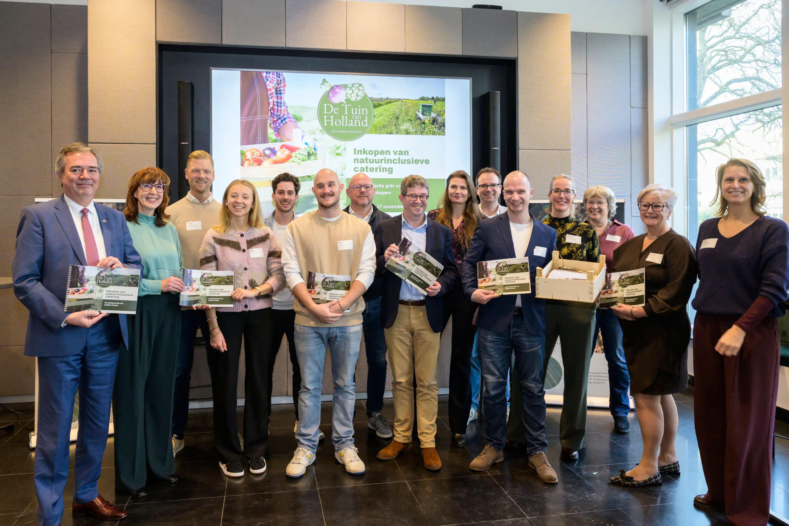 Eerste exemplaar gids wordt aangeboden aan gedeputeerde Meindert Stolk op Provinciehuis Zuid-Holland.