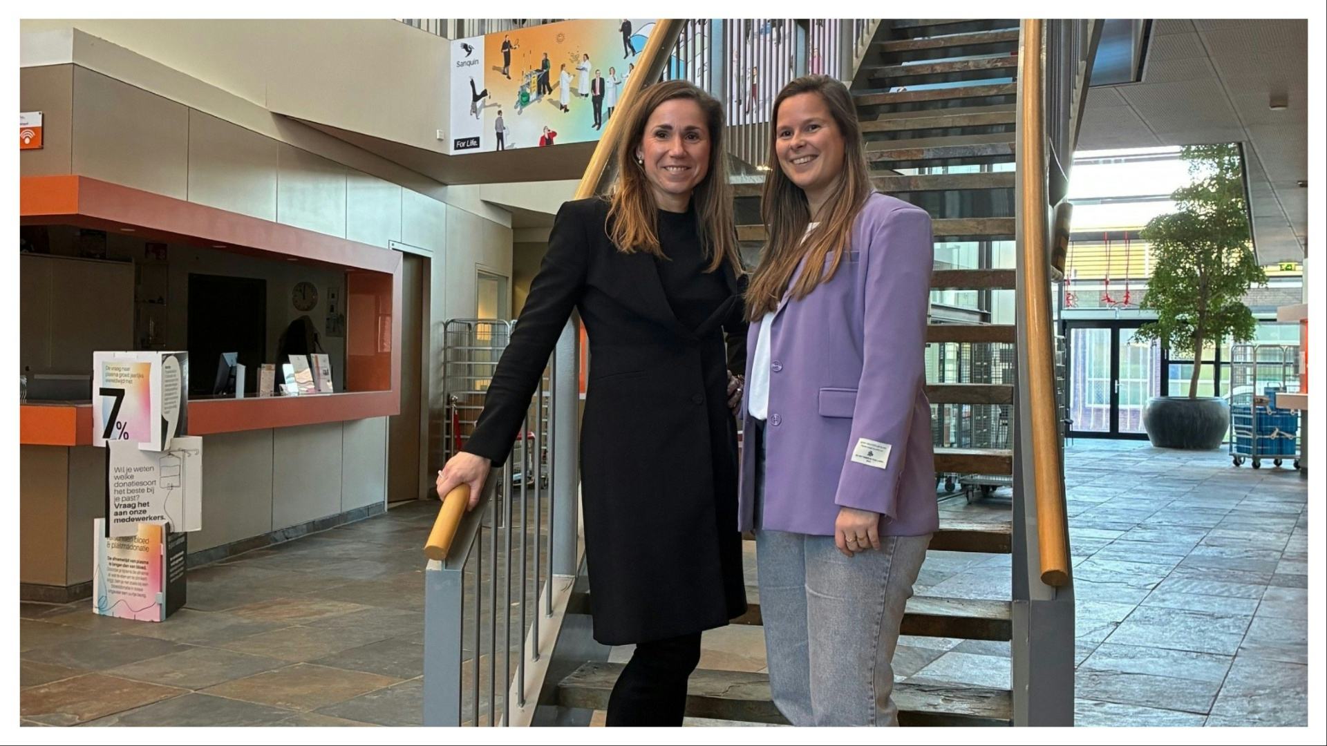 Petra de West (l) en Melissa Heijne (r) in de centrale hal van het hoofdkantoor van Sanquin in Amsterdam (beeld: Lisa Hagoort)