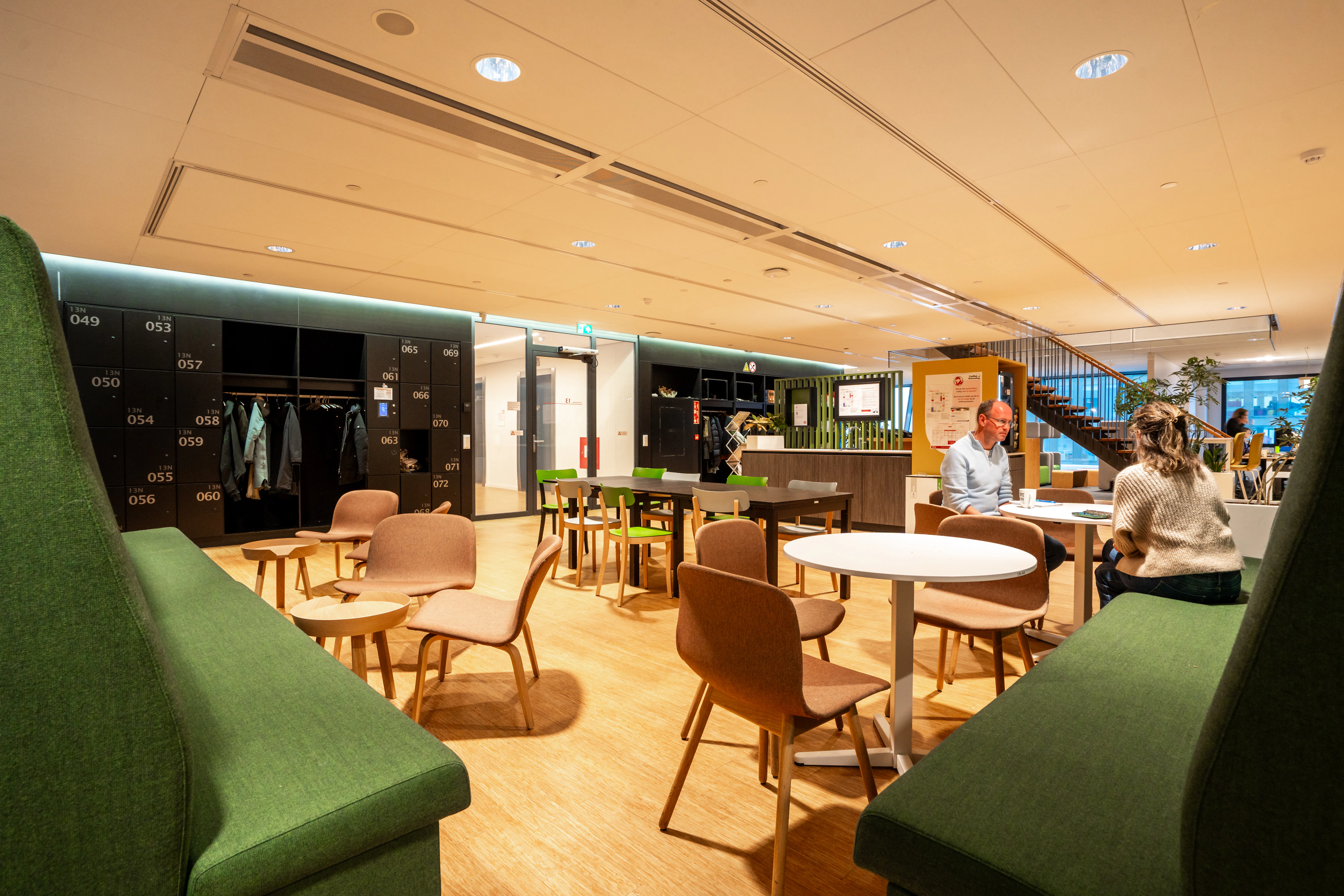 Een huiskamer in de nieuwe situatie. De roze banken zijn opnieuw gestoffeerd in het groen. Foto door Freek van de Weijden